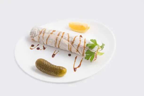 çiğ köfte on plate in front of white background serve with pickle and lemon