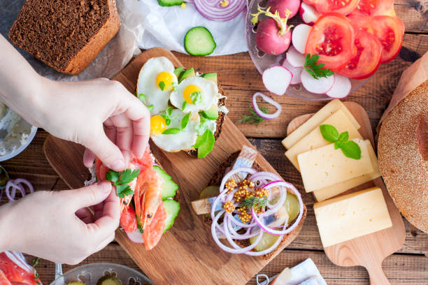 istock Female hands I collect open sandwiches with rye bread, top view, culinary concept, horizontal 1058655362