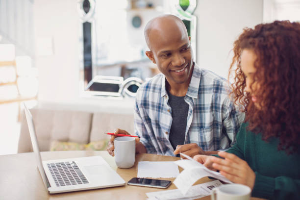 istock Smiling man looking at woman calculating budget 1058656914