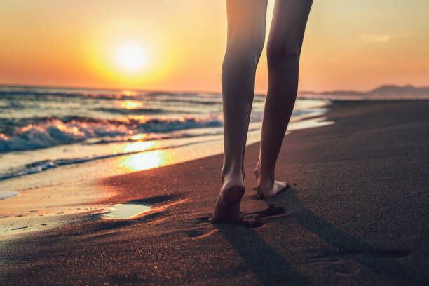 caminando por la playa en el atardecer - one person beautiful barefoot beach fotografías e imágenes de stock