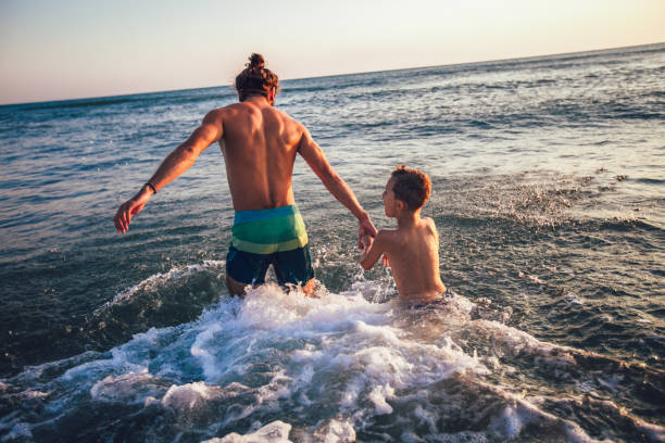 istock Father and son playing on the beach at the day time 1058658192