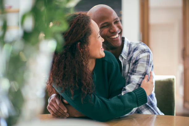 istock Happy couple embracing while sitting at table 1058658272