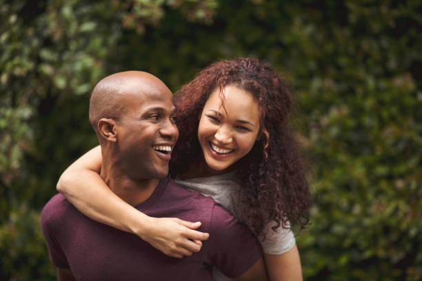 istock Cheerful man giving woman piggyback in back yard 1058663236