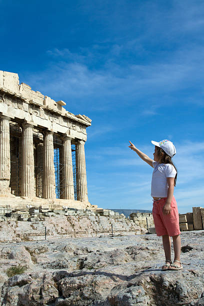 istock Child points to  Ancient Parthenon Facade in Acropolis Athens Greece 105866511