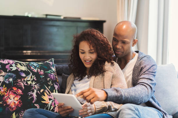 istock Couple relaxing with digital tablet on sofa 1058666482