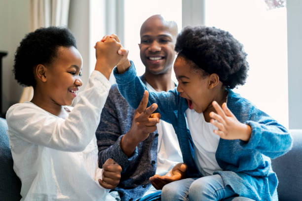 istock Father restraining daughters rough housing at home 1058668674