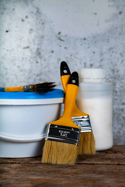 istock Paint can and brush on the table. 1058668966
