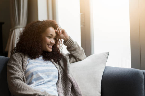 istock Thoughtful young woman looking away against window 1058670462