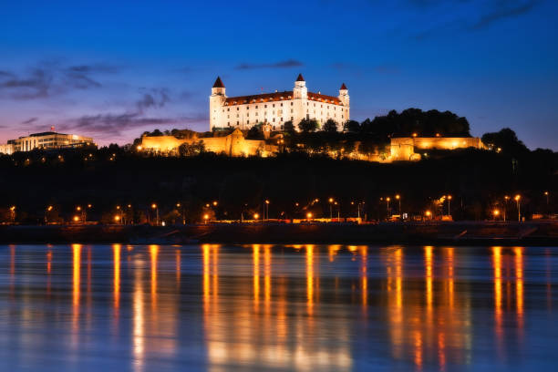istock Bratislava castle at night, city lights reflection in Danube river 1058676418