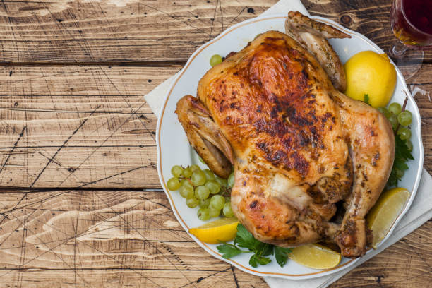 istock Baked chicken, wine glasses and fruit for dinner on the festive table. copy space 1058680572