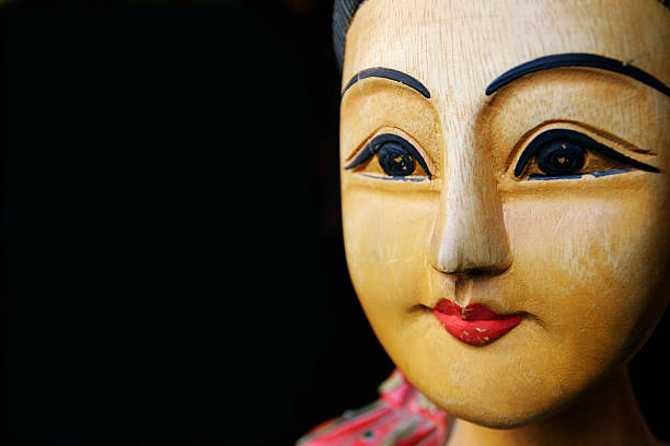 Heads of one black and one white doll on  vintage wooden shelf.
