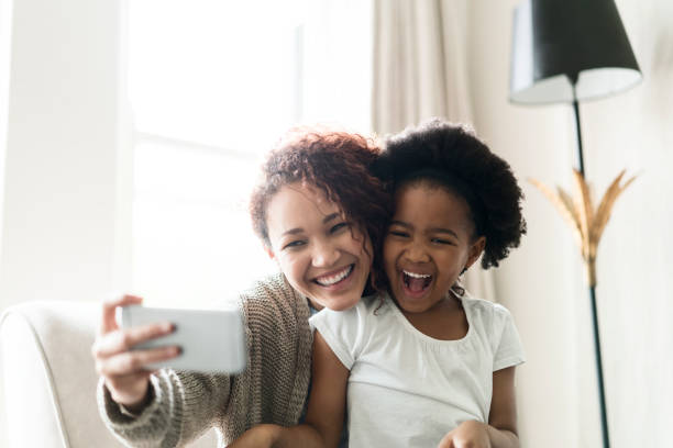 istock Mother taking selfie with daughter through phone 1058684232
