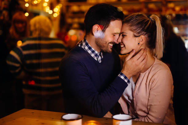 istock Romantic couple dating in pub at night 1058684910