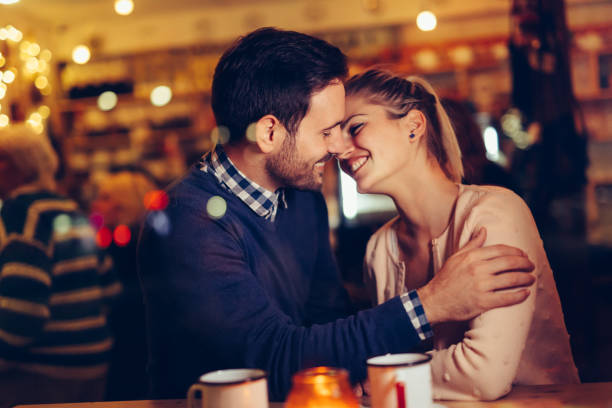 istock Romantic couple dating in pub at night 1058684940