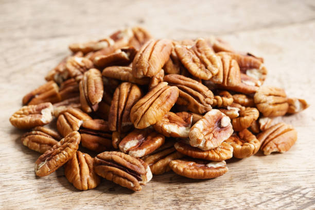 pecan Pecan nuts on wooden background Pecans stock pictures, royalty-free photos & images