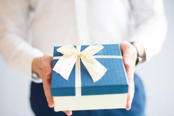 istock Closeup of man giving big gift box with bow 1058687306