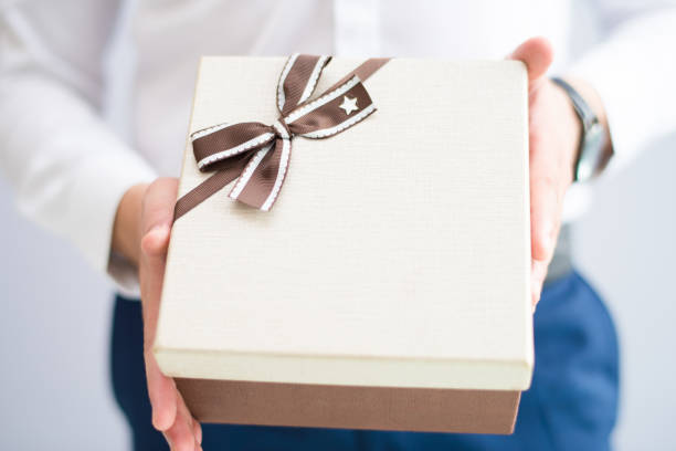 istock Closeup of man giving big gift box 1058687370