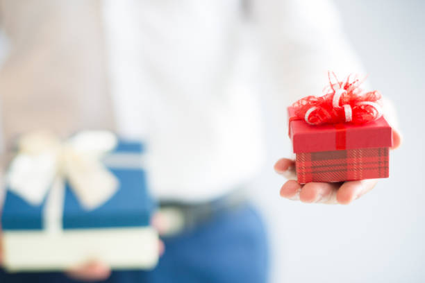 istock Closeup of man holding two gift boxes with bows 1058687372