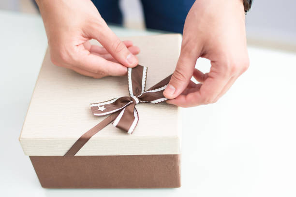 istock Closeup of man wrapping gift 1058687412