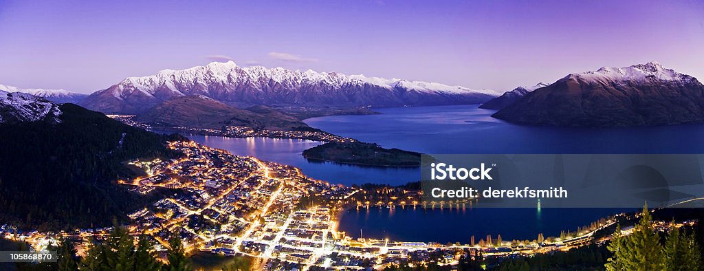 Very High Res Panorama of Queenstown at Night Night time over Queenstown, New Zealand with city lights below. Lake Wakatipu and the Snow Capped Remarkables mountain range. Just after sunset. Queenstown - New Zealand Stock Photo