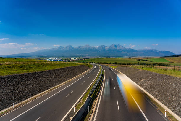 Highway leading to rocky peaks of High Tatras mountains. stock photo