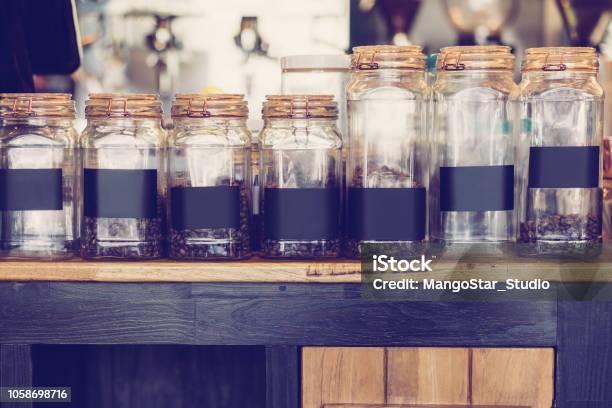 Transparent Jars With Coffee Beans On Table Stock Photo - Download Image Now - Arabica Coffee - Crop, Arabica Coffee - Drink, Authority