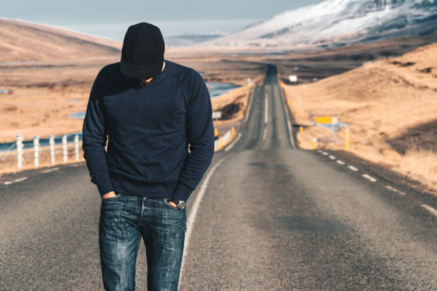 istock man walking alone on the road in iceland 1058699412