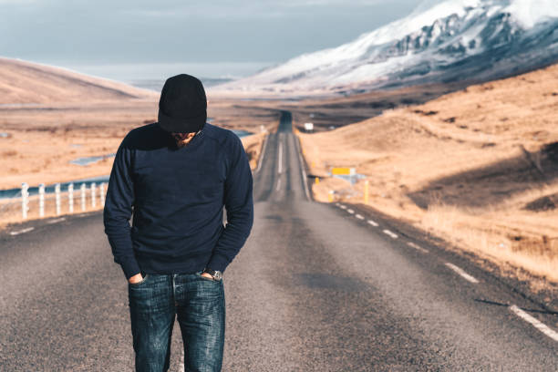 istock man walking alone on the road in iceland 1058699442