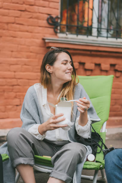 istock Woman eating take out food in box 1058706682