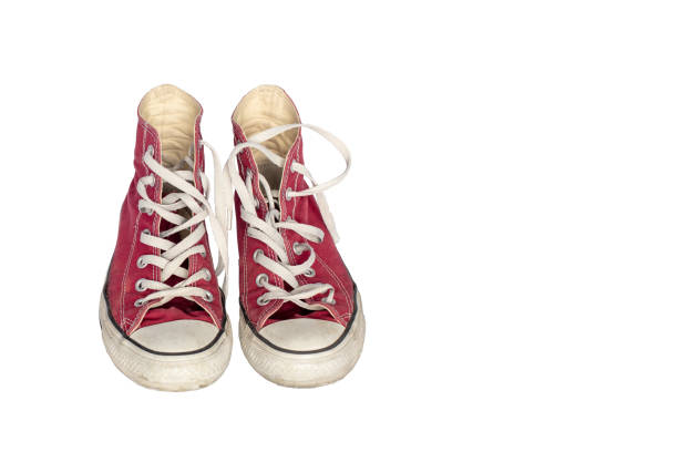 Old dirty shabby red sneakers close-up on a white  background, free space for  text. Old wear out, wear and tear, sports concept.