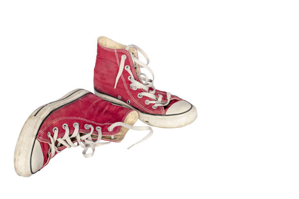 Old dirty shabby red sneakers close-up on a white  background, free space for  text. Old wear out, wear and tear, sports concept.
