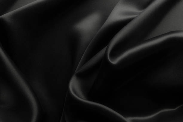 istock Elegant black soft silk with waves, texture background 1058712560