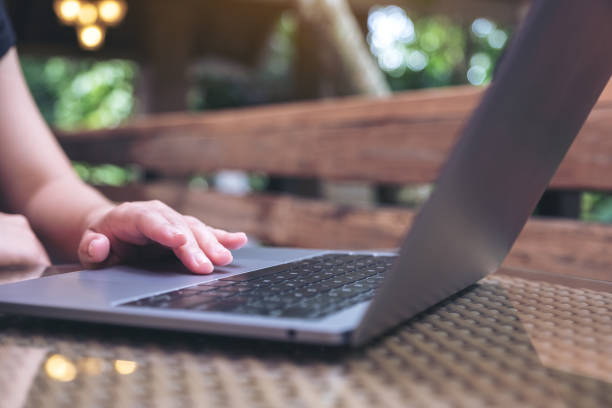 istock Closeup image of hands using and touching on laptop touchpad on wooden table 1058712674
