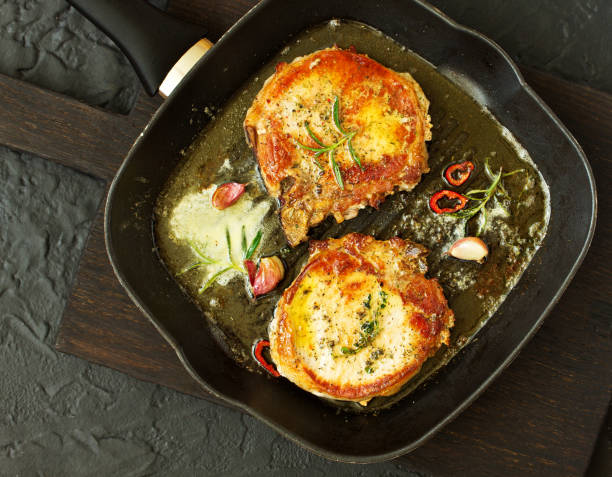 istock Fried pork steak in a frying pan. 1058713016