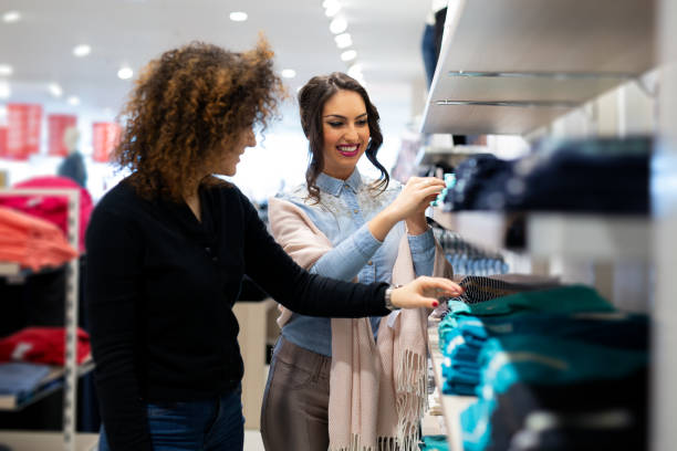 istock Two cheerful girls shopping for clothes 1058715028