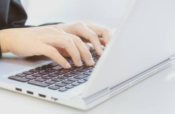 istock selective focus, Cropped shot of  hands typing on laptop's keyboard. 1058717942
