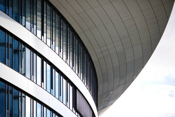 Curved glass facade of modern building with overhanging roof stock photo