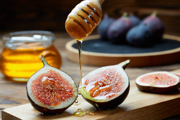 istock Cut figs on a wooden Board watered with honey. Rustic style. 1058718468