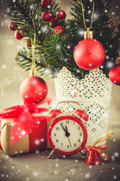 istock Christmas composition: xmas fir branches, alarm clock, gift box and decorations. 1058719638