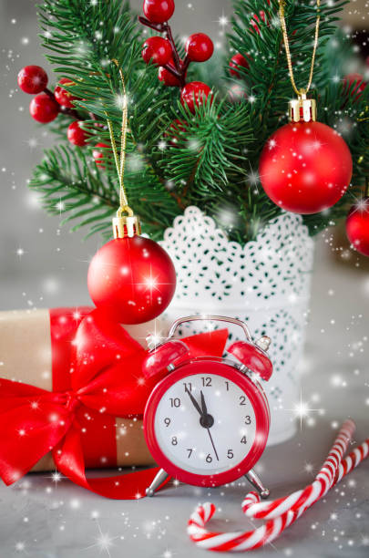 istock Christmas composition: xmas fir branches, alarm clock, gift box and decorations. 1058719666