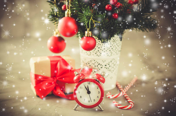 istock Christmas composition: xmas fir branches, alarm clock, gift box and decorations. 1058719720