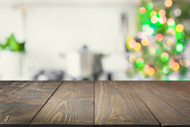 istock Empty wooden tabletop for display products and blurred kitchen with Christmas tree as background. 1058724294