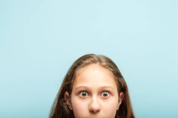 istock startled surprised shocked girl peeking out bottom 1058729622