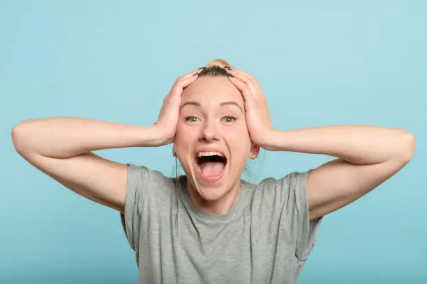 Photo of excited enthusiastic woman scream hold head hands