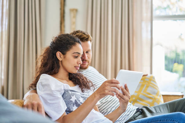 istock Young man looking at woman using digital tablet 1058729846