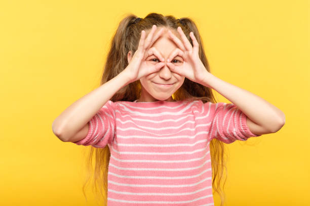istock funny joyful playful girl look hand binoculars 1058730502