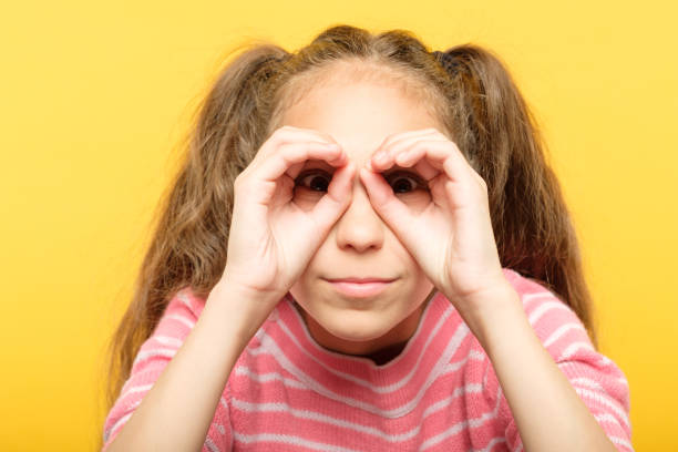 istock girl pretending look binoculars hands search 1058730558