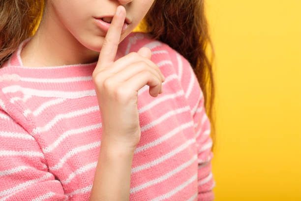 istock silence quiet girl shushing putting finger lips 1058730762