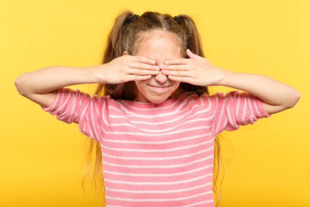 istock see no evil smiling girl covering eyes hands 1058730810