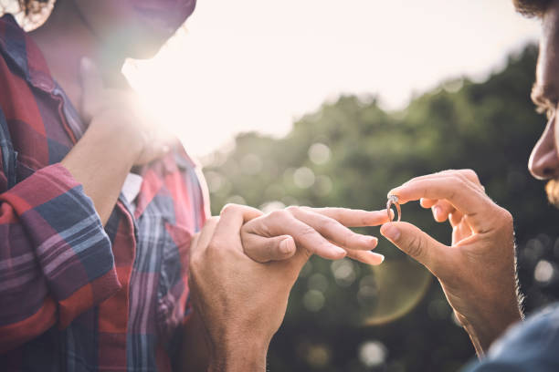 Close-up of man putting ring on woman's finger